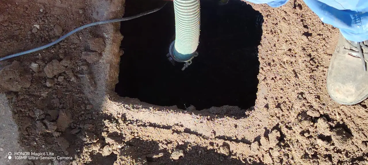 Manguera de succión profesional extrayendo desechos de un pozo séptico durante un servicio de mantenimiento y saneamiento ambiental.