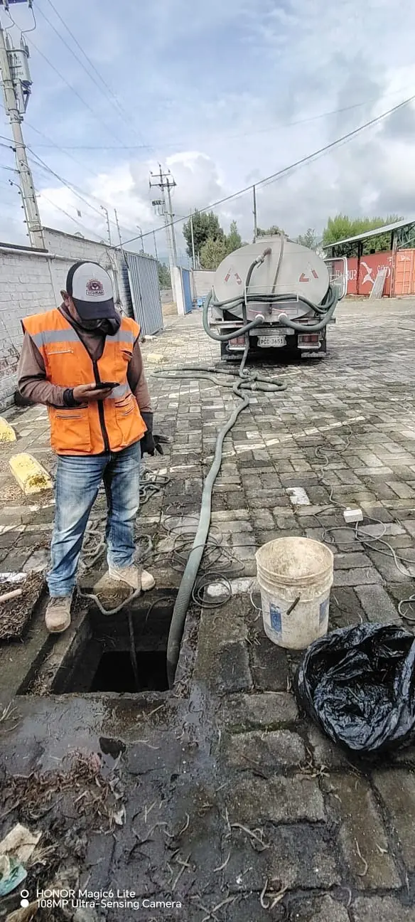 Operario de Saneamiento RAMGL realizando limpieza técnica de trampas de grasa y tuberías en un negocio local.